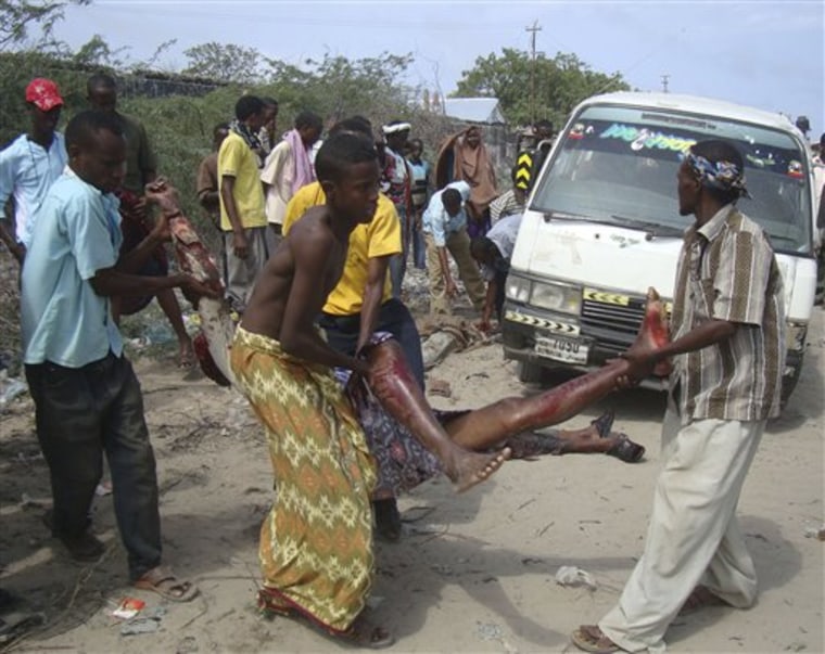 Somalis carry a wounded civilian who was injured in a roadside bomb blast that missed African Union (AU) peacekeepers and struck a civilian transport truck, killing four civilians, in southern Mogadishu Somalia Tuesday June, 21, 2011(AP Photo/Farah Abdi Warsameh)